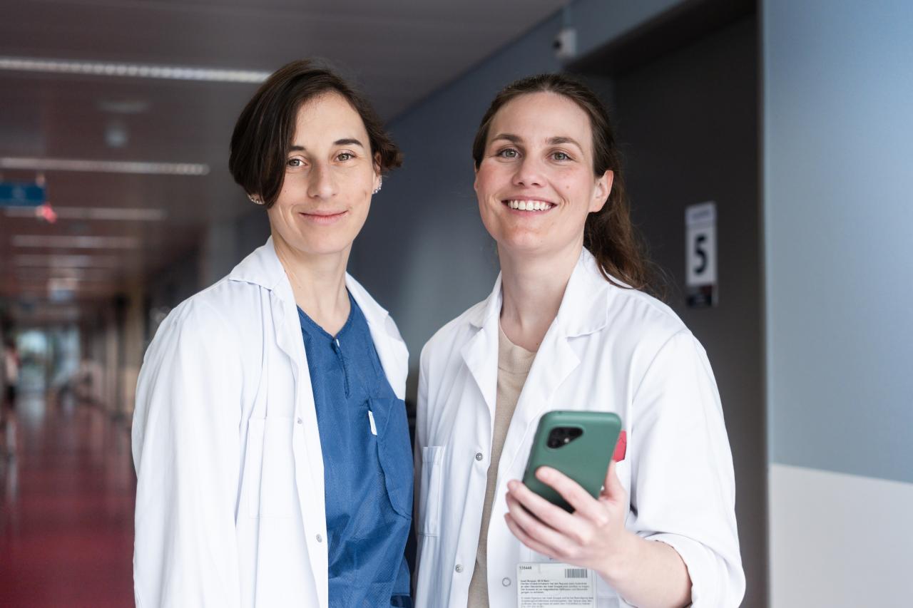 Zwei Ärztinnen lächeln in die Kamera