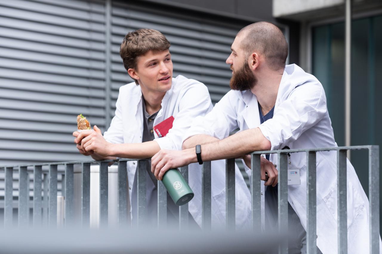 Ärzte stehen auf dem Balkon und reden miteinander