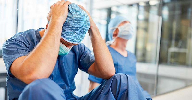 Chirurg sitzt verzweifelt am Boden